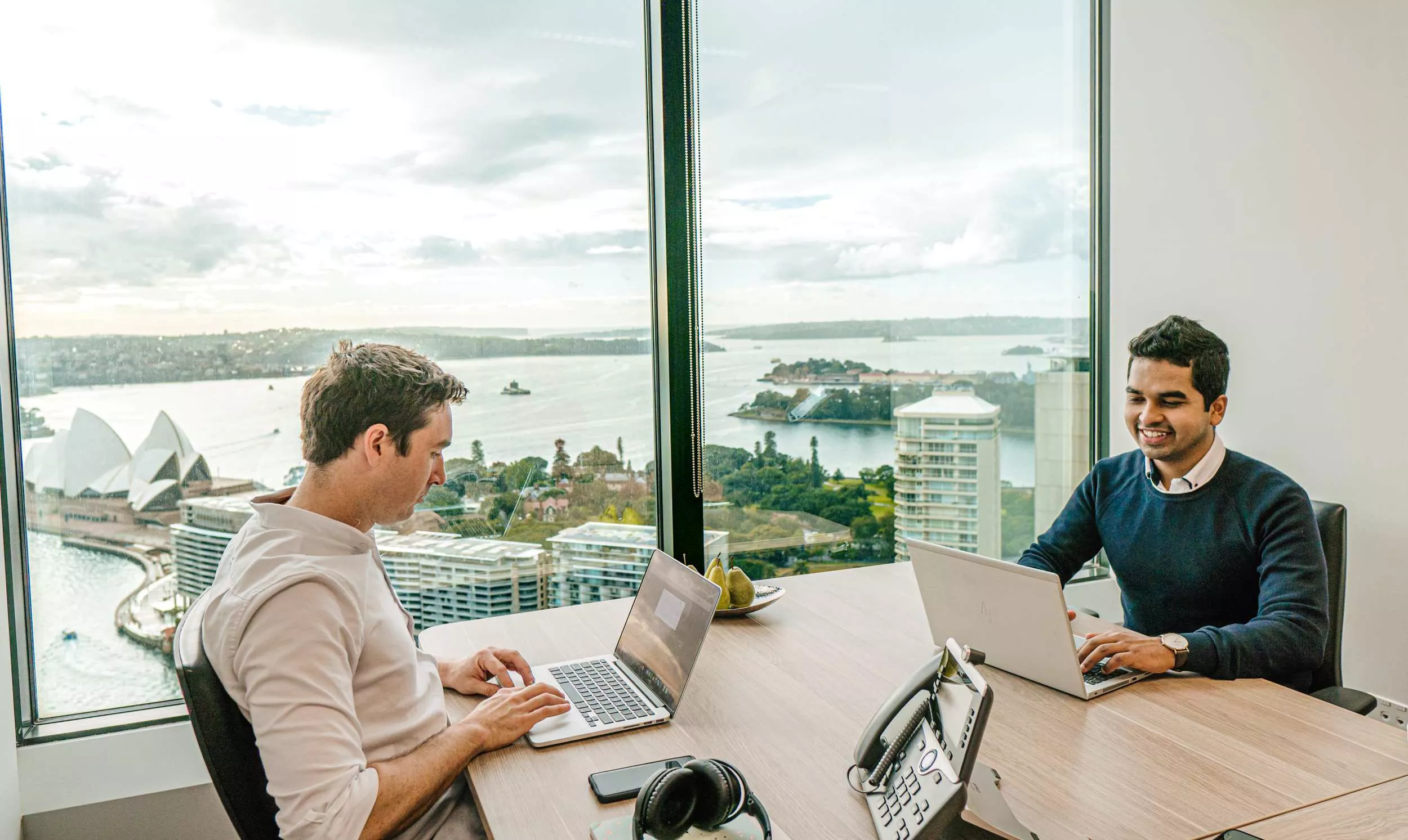 Clients working in a serviced office at Servcorp with stunning harbour views.